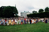 Midsommarfirande vid Gunnebo slott i Mölndal på 1990-talet. Dans kring midsommarstången. Slottet i bakgrunden-