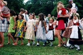 Midsommarfirande vid Gunnebo slott i Mölndal på 1990-talet. Små och stora deltar i dansen kring midsommarstången.