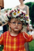 Midsommarfirande vid Gunnebo slott i Mölndal på 1990-talet. Porträtt av en liten flicka med blomsterkrans på huvudet.