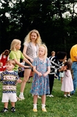 Midsommarfirande vid Gunnebo slott i Mölndal, okänt årtal. Små och stora deltar i dansen kring midsommarstången.