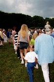 Midsommarfirande vid Gunnebo slott i Mölndal, okänt årtal. Små och stora deltar i dansen kring midsommarstången.