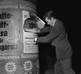 Einar Kindgren klistrar upp affischer på yttre borggården inför valet 1954