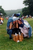 Midsommarfirande vid Gunnebo slott i Mölndal, okänt årtal. Två kvinnor tar skydd undan regnet med hjälp av en filt.