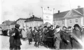 Demonstrationståg i och med första maj under första världskriget, troligen 1918. En fana med text: 