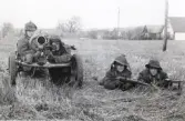 Strid i Hörle, Värnamo, 1968-04-03.
Pansarvärnsgrupp i eldställning på en åker. I bagrunden skymtar bebyggelse.