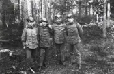 Repetitionsövningarna vid I11 i Växjö, hösten 1921.
Fyra man i uniform m/10 i ett skogsbryn.