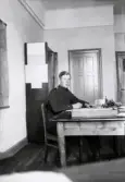 Repetitionsövningarna vid I11 i Växjö, hösten 1921.
6:e kompaniets expedition. En ung man i uniform sitter vid skrivbordet.