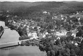 Flygfoto över Oskarström från 1935 med ån Nissan i bildens vänstersida. Över ån finns två broar och bortanför ortsbebyggelsen ligger en åker med stackar av hö eller sädesnekar. (Se även bildnr F9351.)