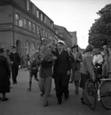 Studenterna, 1939. En student bärs fram längs Kungsgatan, söderut. I bakgrunden skymtar hörnet mot Storgatan (dåv. Skånska Banken, nuv. Adenmarks affär).