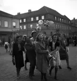 Studenterna, 1939. En kvinnlig student bärs iväg längs Stortorget av sina kompisar. I bakgrunden syns dåv. Skånska bankens hus m.m. i början av Storgatan.