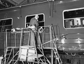 Glasmästare Pettersson monterar fönster på en passagerarvagn på Centralverkstäderna, 1960-tal