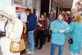 Medlemmar i fotbollsföreningen Jitex BK delar ut blommor till folk i Mölndals centrum i mars 1992. Kvinnor och män får blommor i kön till Minuten-automaten på Brogatan.
