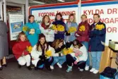 Medlemmar i fotbollsföreningen Jitex BK delar ut blommor till folk i Mölndals centrum i mars 1992. Grupporträtt av Jitex-spelare som har blommor att dela ut. Fotograferat utanför K-marknad på Brogatan.