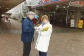 Medlemmar i fotbollsföreningen Jitex BK delar ut blommor till folk i Mölndals centrum i mars 1992. En man får blommor i korsningen Brogatan-Nygatan. K marknad i bakgrunden.