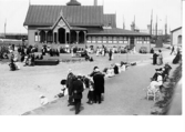 Varmbadhusets södra fasad med veranda och tillbyggnad. Strandpromenaden. Barnens badstrand.