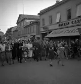 Studenterna, 1939. Studenterna tågar fram på Kungsgatan, norrut. Till höger syns dåv. Philip Carlssons affär. I bakgrunden skymtar kupolen till dåv. Växjö Högre Allmänna Läroverk.