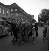 Studenterna, 1939. En kvinnlig student bärs fram på Kungsgatan. I bakgrunden syns dåv. Skånska bankens hus (numera Adenmarks affär).