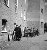 Kamratmötet, I 11. Förevisande av diverse saker, bl a gasmasker, utanför en av 
kasernerna.