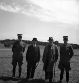 Kamratmötet, I 11. Samling på övningsfältet. Några herrar i uniform (m/23) med
några civila herrar i hatt och kostym m.m.