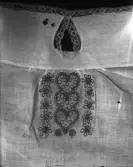 Nattkappa broderad i kedjesöm (ev. tambursöm), kantad med spets.

21287 inristat i glasplåten (trol.föremålsnummer).

