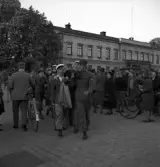Studenterna 1940. 31/5 - 1/6. En manlig student bärs av sina kompisar längs Stortorget. I bakgrunden syns Residenset.