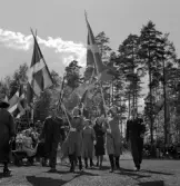 Medborgartåget, 16/6 1940. Fanborg på Värendsvallen. Några lottor marscherar fram med flaggor, följda av några herrar i kostym.