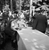 Medborgartåget, 16/6 1940. 
Tecknande av försvarsobligationer. En hel del folk har samlats runt de
olika bankrepresentanterna.