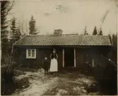 Kvinna och barn framför byggnad