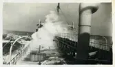 Fotografi föreställande ett fartyg på havet med höga vågor som omger skeppet. 1900-tal. Från Gunnar Henrikssons samling.