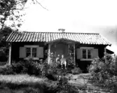 Grödinge. Okänd stuga med två personer