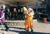Påskfirande på Mölndals torg lördagen den 3 april 1999. Frälsningsarméns hornmusikkår spelar på den lilla scenen och tre påskkärringar dansar till musiken.