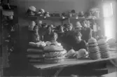 Personalen på AB Lindberg strå- och filthattfabrik med olika hattar, 1910-tal