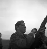 Hemvärnet. 20/4, 1941.
En ung man justerar något på sitt gevär.