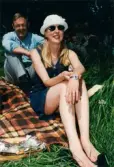 Midsommarfirande vid Gunnebo slott i Mölndal, år 1999. Porträtt av en kvinna och en man som sitter på en filt i gräset.