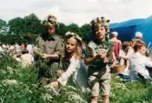 Midsommarfirande vid Gunnebo slott i Mölndal, år 1999. En flicka och två pojkar plockar blommor. Alla tre har blomsterkransar på huvudet.