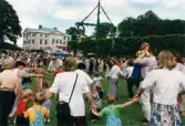 Midsommarfirande vid Gunnebo slott i Mölndal, år 1999. Dans kring midsommarstången för små och stora. Slottet i bakgrunden.