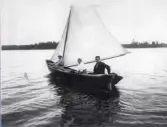 Tre personer ute och seglar med storekan 