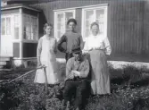 Fiskare Viktor Berg, framför sitt hus, med hustru Betty, adoptivsonen Vilgot och pigan i huset.
