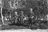 Tre små barn i trädgård, 1920-tal