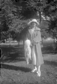 Kvinna i hatta och kapp samt en vit boa, 1920-tal