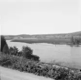 Falun, kring Hosjö. Från Stämshöjen, Backa bro. Väg mot Hosjöholmen, i bakgrunden syns gårdarna i Östborn och Solbacka.