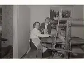 Vävning. Två kvinnor vid en vävstol. Troligen i Rolfstorp eller Skällinge, fotografens hemvist. Uppgifter om bilden saknas.