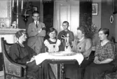 Familj vid runt bord i hemmet, 1920-tal