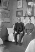Äldre par sitter i soffa, 1920-tal