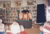 Barn ser en dockteater-föreställning med Blanka Kaplan, som visades under Barnkulturveckan år 1997. Anordnad av SV (Studieförbundet Vuxenskolan) på Kållereds bibliotek. I bakgrunden ses böcker i bokhyllor. Relaterade motiv: A4527 - A4530.