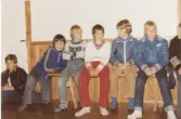 Elever sittandes inomhus på en träbänk, Brattåsskolan 1980-tal. Foto från läraren Rolf Werners album.