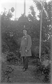 Man i hatt och överrock i park under fantasifull belysning, 1920-tal