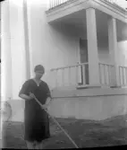 Kvinna krattar en grusgång, 1920-tal