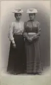 Systrarna Alma och Maria Karlsson i sina nya hattar hos fotografen, omkring 1905