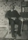 Johan Karlsson vilar sig i en korgstol i hemmet i Lillkyrka, omkring 1920 